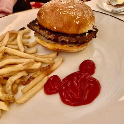 hamburger and French Fries on a plate with ketchup that has been made into a Mickey Mouse head.